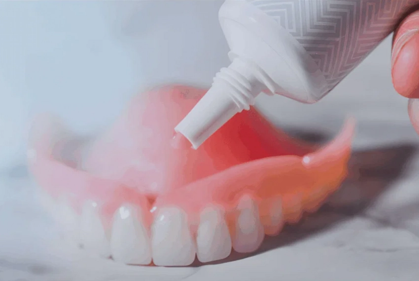 applying adhesive paste to traditional denture applying adhesive paste to traditional denture