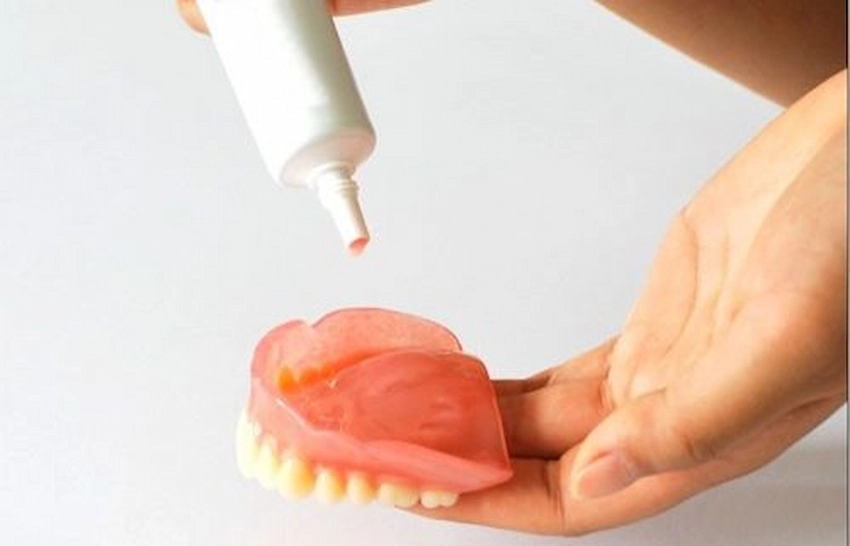 applying denture adhesive to lower denture